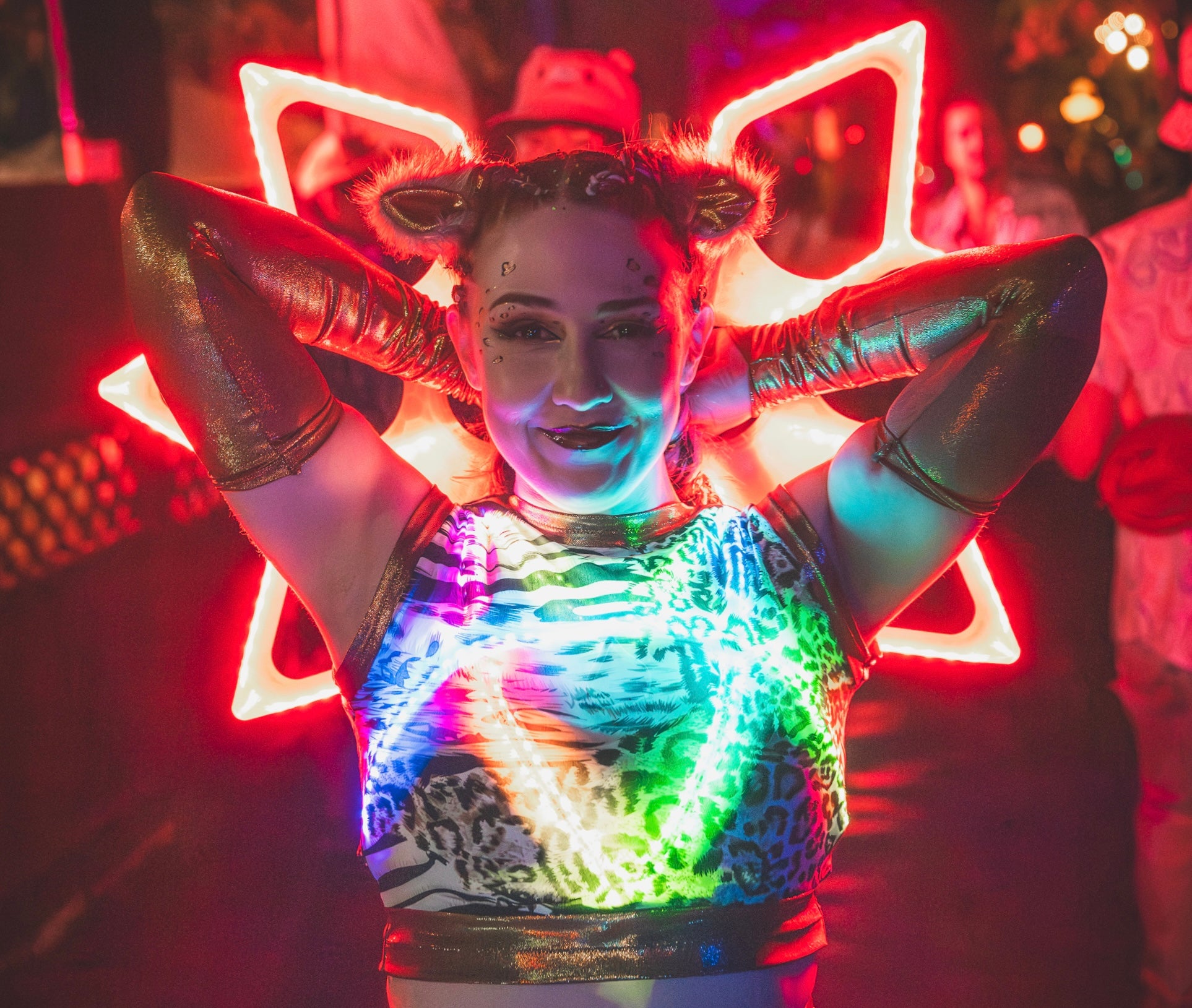 Person wearing a colorful LED outfit with neon lights in a club setting